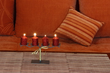 four candles with candlestick and sofa