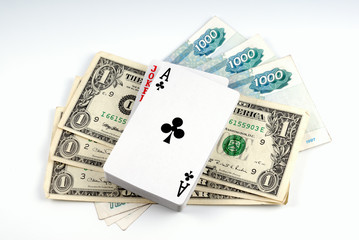 Banknote dollar and banknote rouble laid by fan and playing card