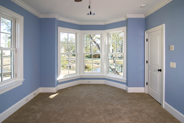 blue bedroom with lots of windows looking out onto pond