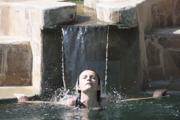 beautiful brunette caucasian relaxing in a swimming pool