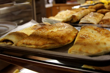 calzones in food showcase in pizzeria