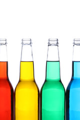 glass bottles with red, yellow, green, and blue liquids