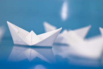 Few paper origami boats floating in blue water