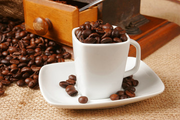 Coffee cup surrounded by coffee grains