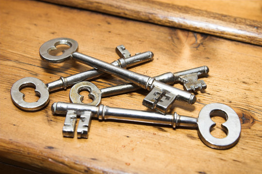 Antique door keys on a wooden surface