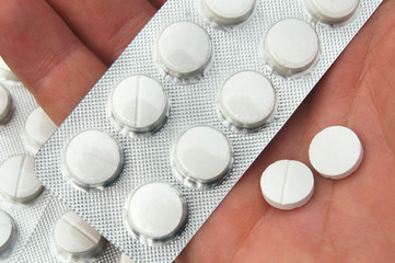 Human hand with white pills