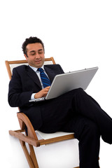 happy businessman with laptop on a chaise longue
