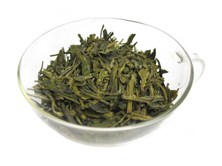 A glass cup of dried green tea