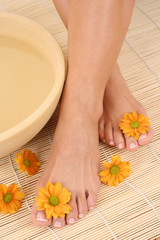Obraz na płótnie Canvas beautiful leg - beauty treatment - bowl of pure water