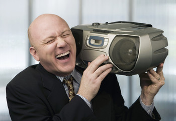 Bald businessman listening to a boom box © Scott Griessel