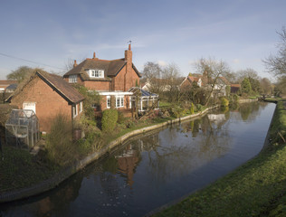 Fototapeta na wymiar Houses next to canal or river.