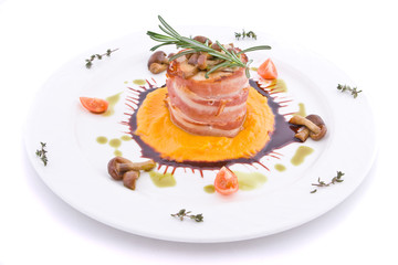 Dish with meat of the rabbit wrapped up by bacon