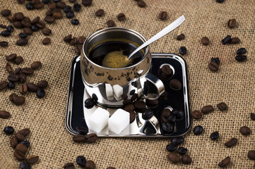 Coffee cup and beans on coffee sack background