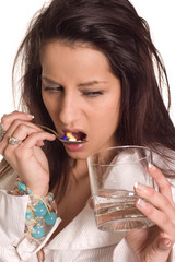Young woman drinking pills against cough and cold