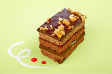 Chocolate cake with soft shadow on green dish. Shallow DOF