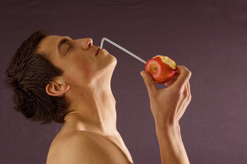 Young athlete man drink juice from apple
