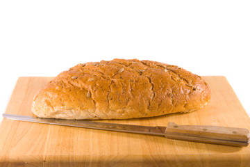 Loaf of Bread and Knife on Bread Board