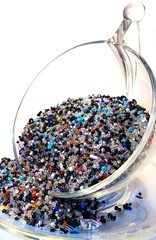 Transparent cup, plate and a lot of beads on white background