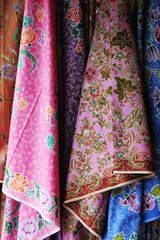 Colorful Batik saris hanging in an Asian market.