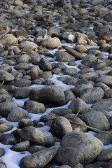 Dry river bed in winter: pebbles, mud and snow