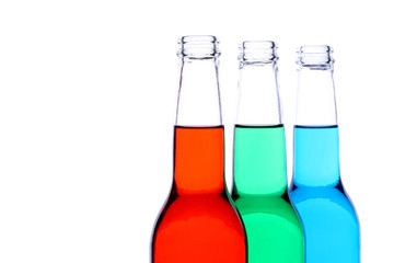bottles with red, green, and blue liquid closeup isolated