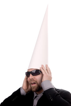 Man in a dunce  cap with sunglasses over a white background