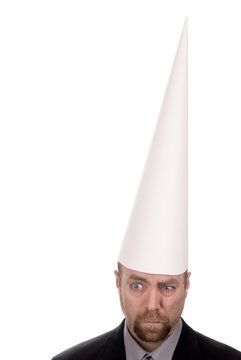 Man in a dunce cap over a white background