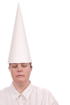 Woman in a dunce cap with eyes closed over a white background
