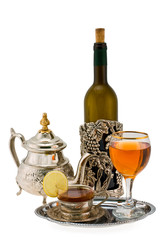 Tea with a lemon and wine in ancient silver utensils
