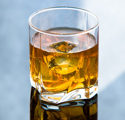 Whiskey in glass with ice cubes