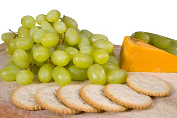 Cheese and biscuits with grapes on wooden board