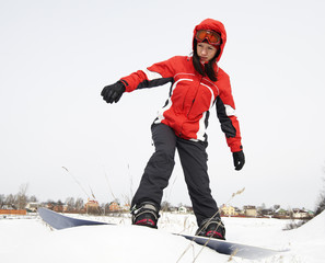 Fototapeta na wymiar young adult female (age 20-25) snowboarder