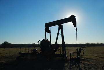 Silhouette pump jack backlight by the afternoon sun.
