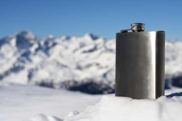 winter season on snowy mountain and silver flask