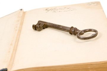 An old key sits on top of an old book. unlocking the past