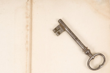 An old key sits on top of an old book. unlocking the past