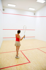 woman playing squash in the squash court