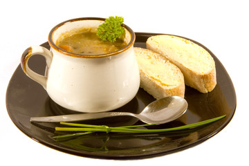 Mug of Soup on Black Plate with Bread and Garnish
