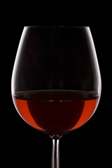 Isolated red wine glass over a black background