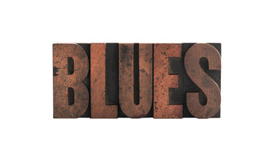 the word 'blues' in old, ink-stained wood letters