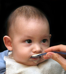 The small child feed with a porridge