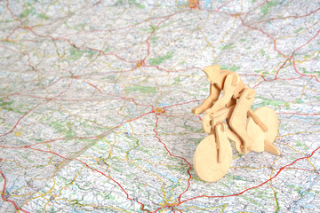 Wooden model of bicyclist on background of map