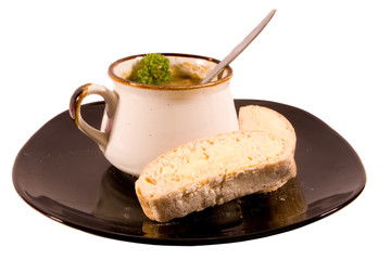 Mug of Soup on Black Plate with Bread and Garnish
