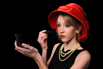 Beautiful young woman with red hat applying make up