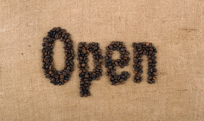 The word Open from coffee beans on linea material