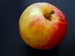 red juicy apple against the black background
