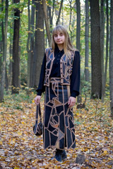 Portrait of the beautiful girl in autumn forest.