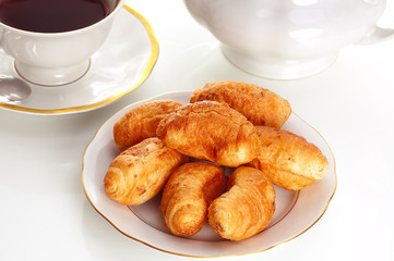 cup of tea and croissants on white