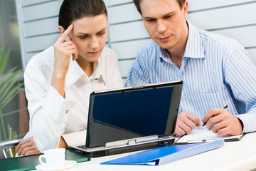 Obraz premium Business woman and businessman looking at the monitor 