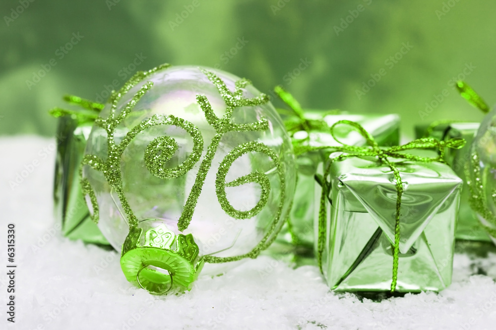 Wall mural green christmas ball and gift boxes on snow